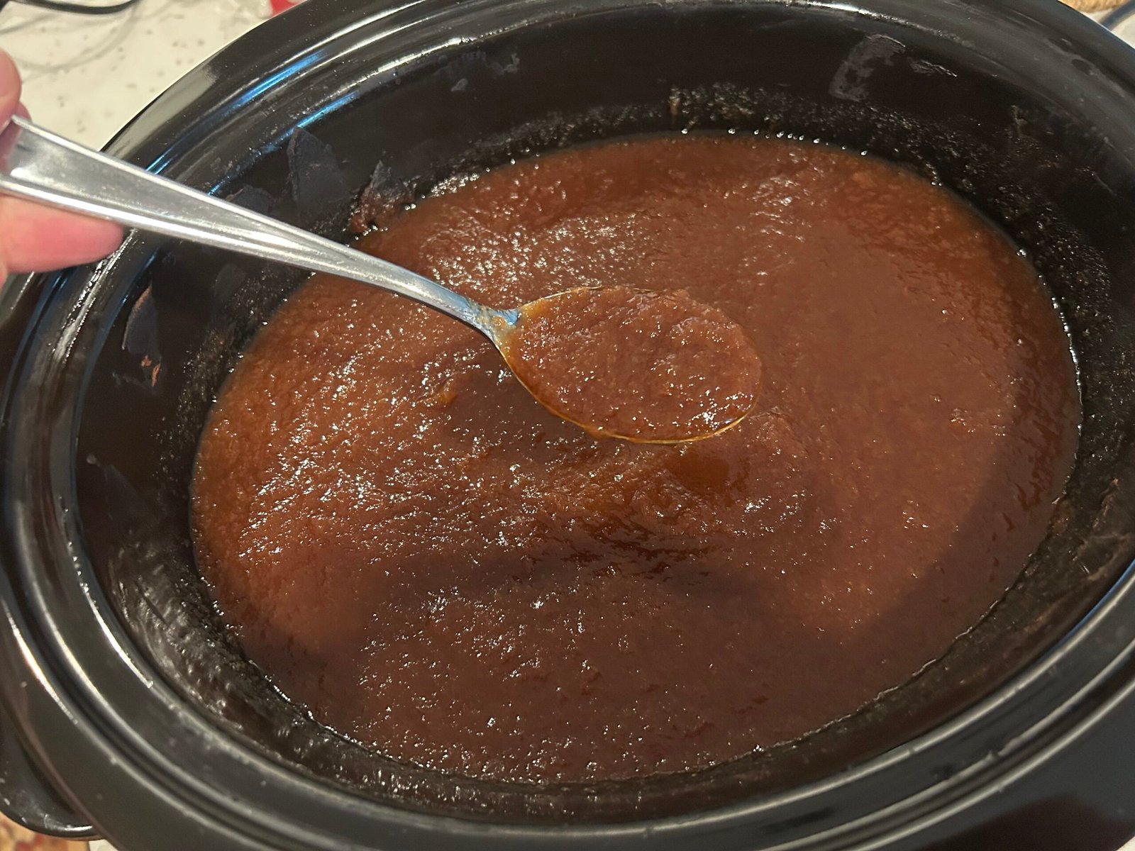 cooked apple butter in black crock pot