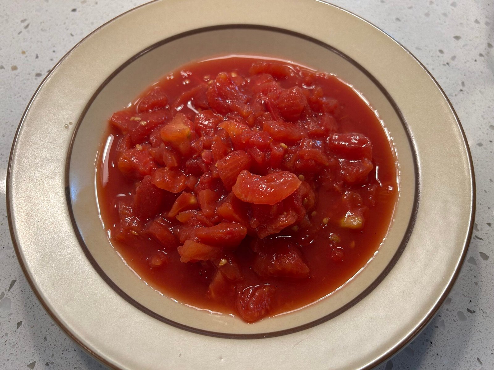 Diced tomatoes in a brown bowl.