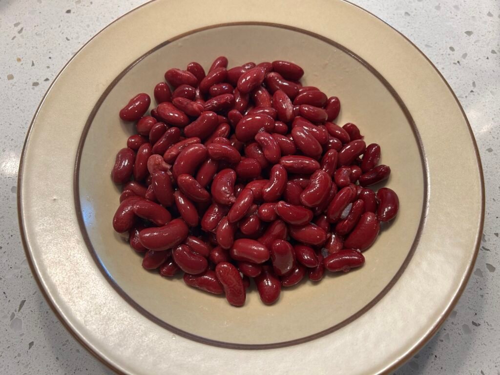 Dark red kidney beans in a brown bowl.