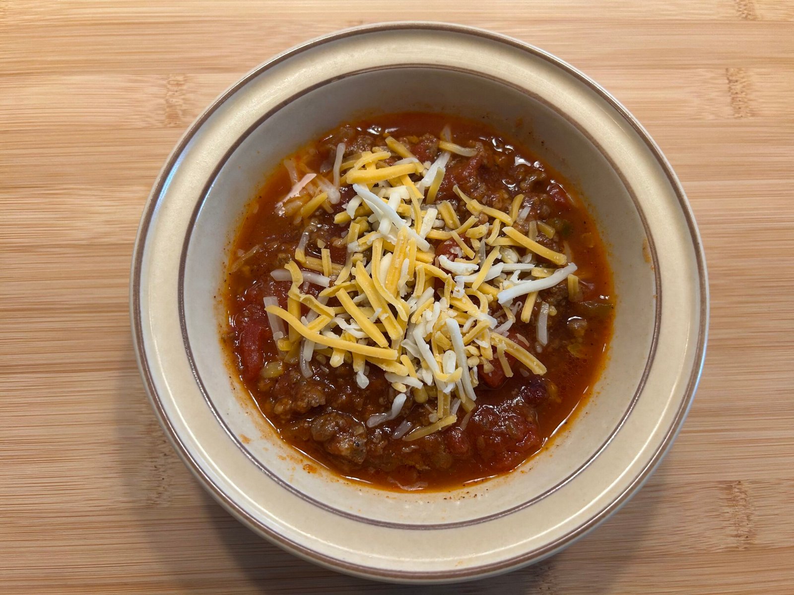 Homestead chili in a brown bowl on a wooden table.