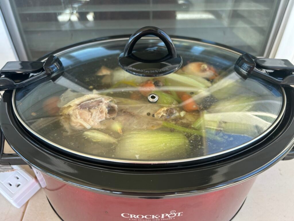 Close up picture of a crock-pot filled with vegetable scraps to make broth.