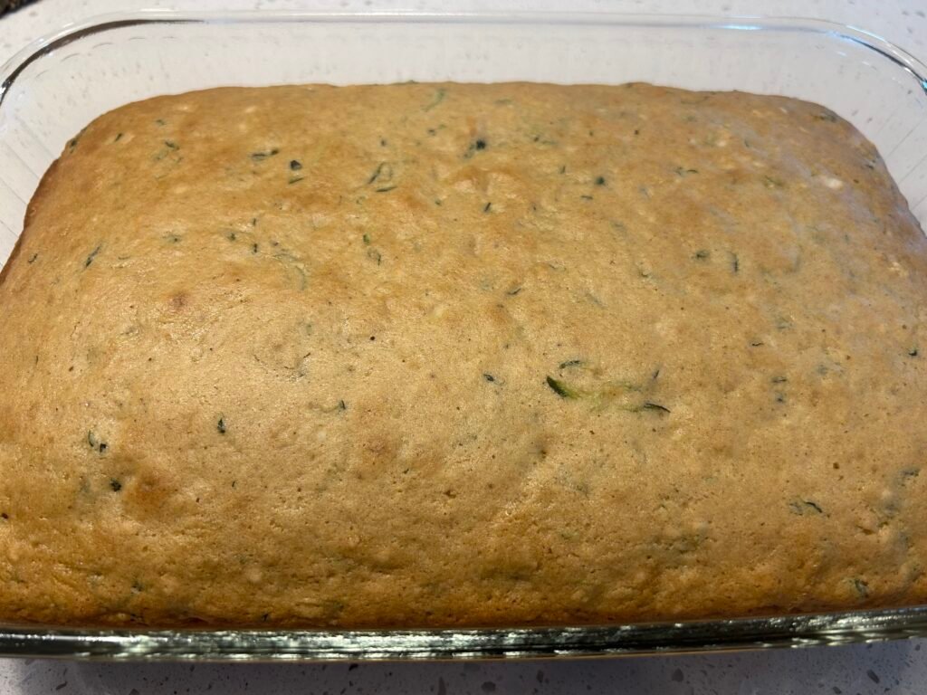 baked zucchini cake cooling on a white counter