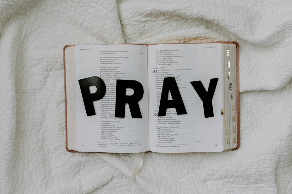 Simple living tip of pray on an open bible on a white table cloth