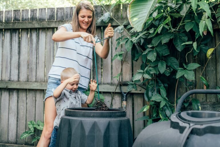 A mother with her little son mixing compost in the garden
