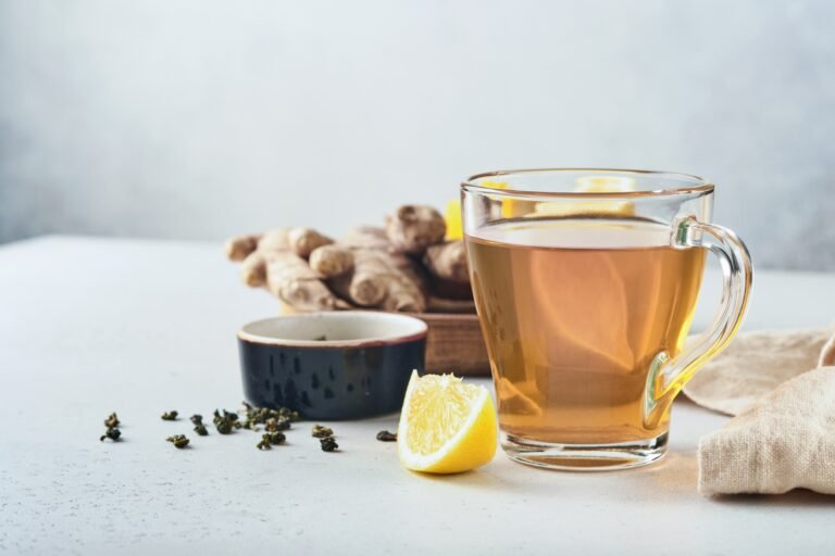 Ginger tea. Cup of ginger tea with lemon, honey and mint on grey background. Concept alternative med